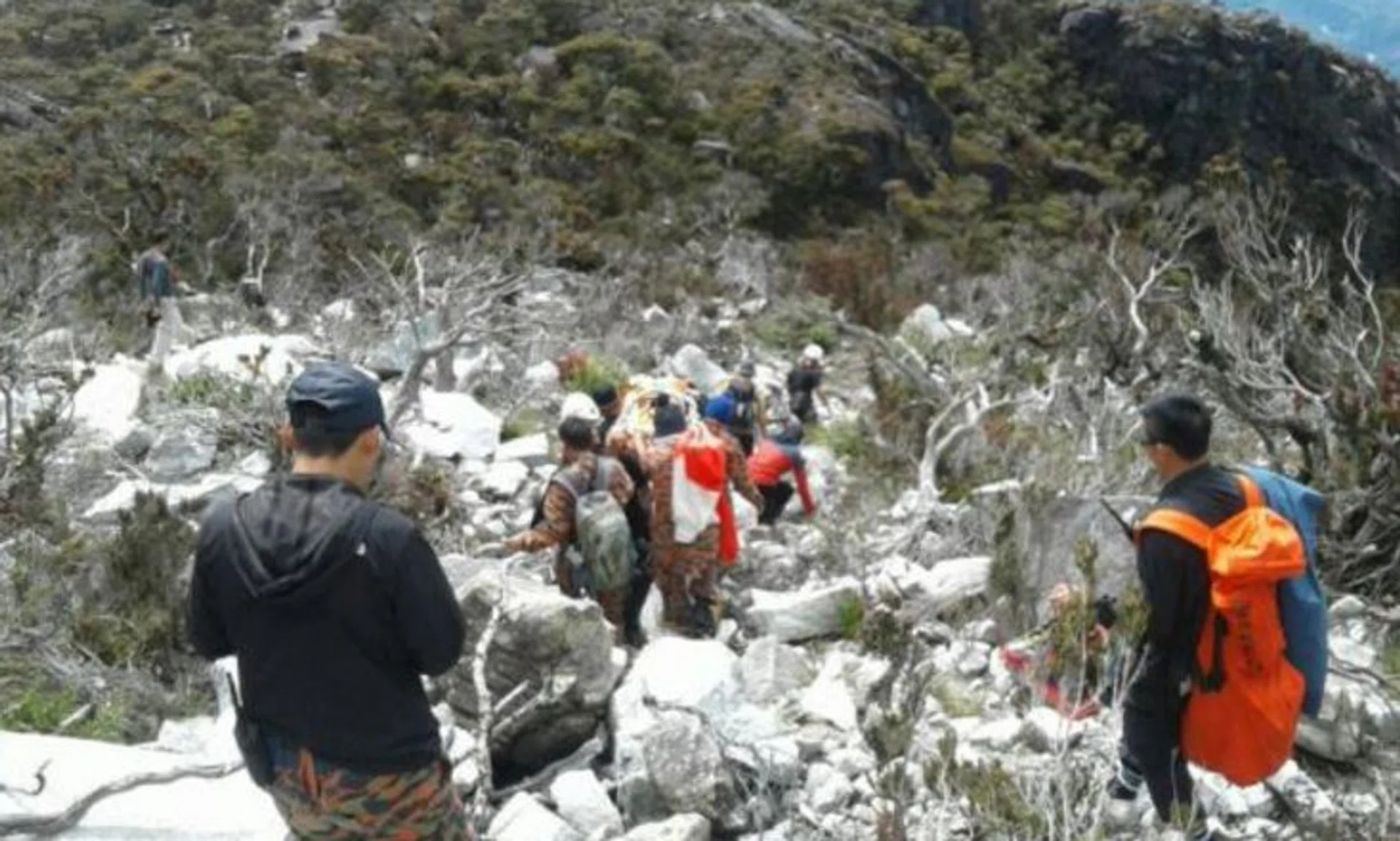 Rescuers bringing down Woon's body from Sayat-Sayat on Sunday.