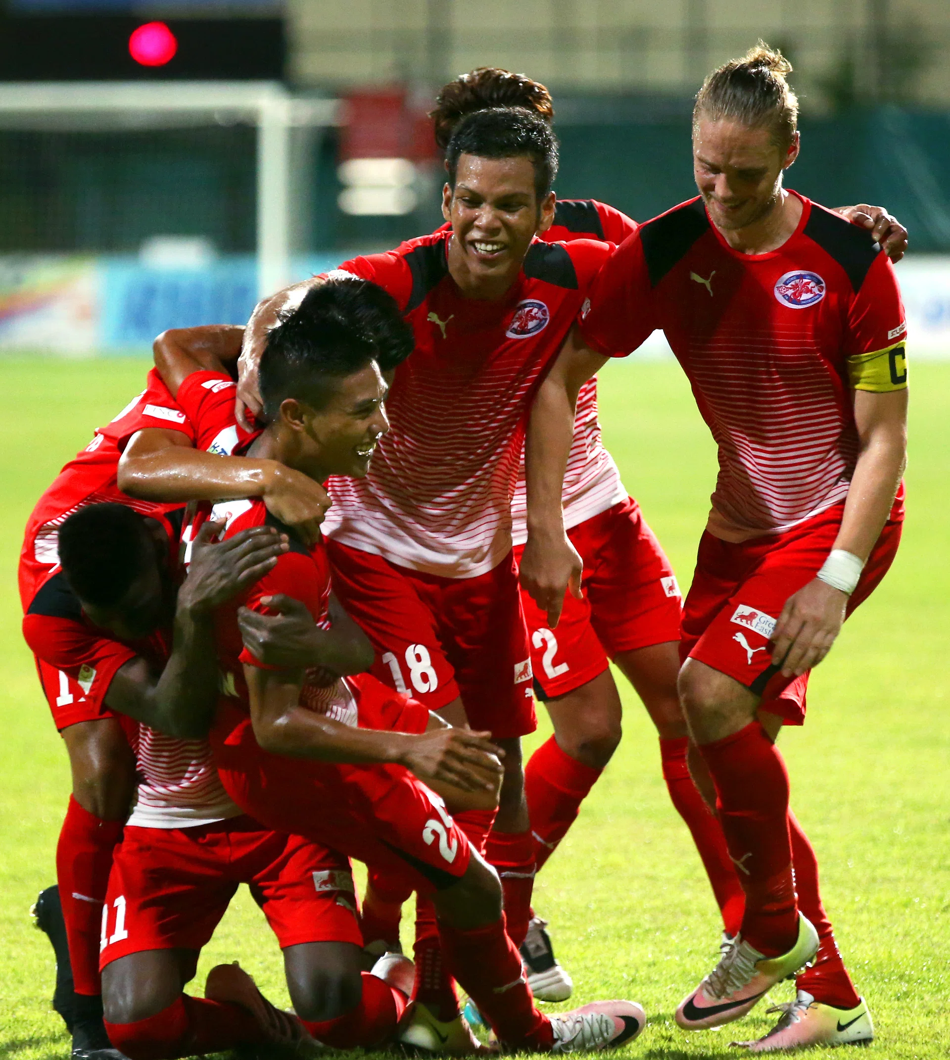 HIGH FIVE: Home United players celebrating their fifth goal by hugging the scorer Syahiran Miswan (No. 24). 