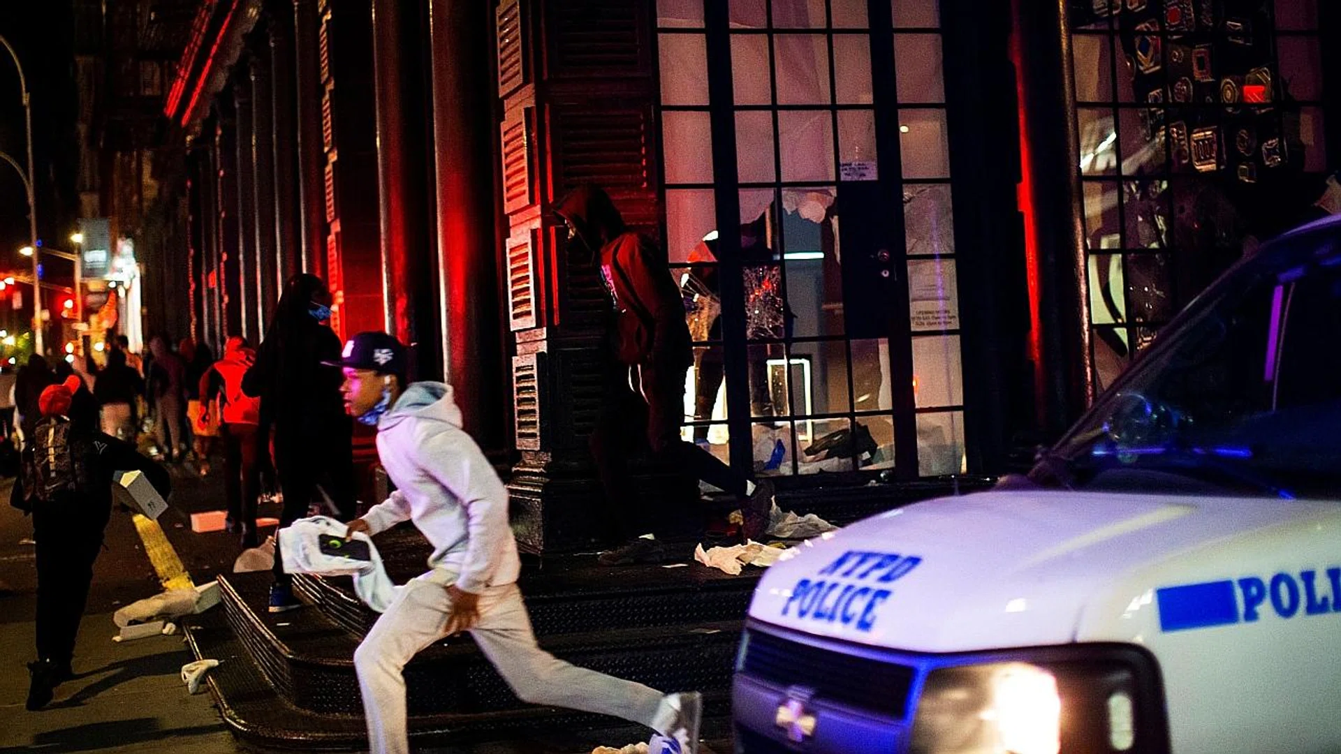Protesters confronting police outside the White House in Washington. (Above) Protesters fleeing after looting a store in the Manhattan borough of New York City. 