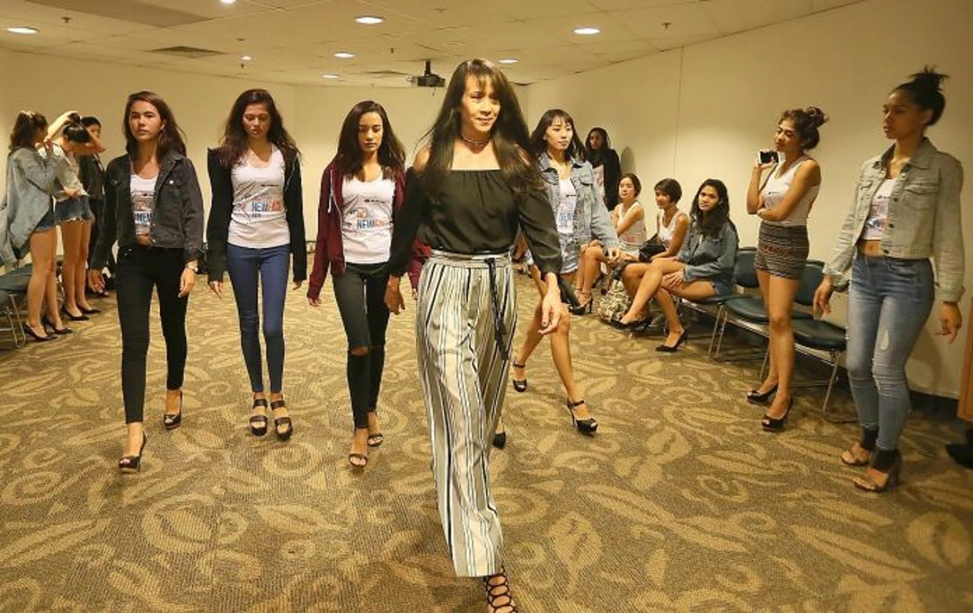 LEARNING FROM THE BEST: Pat Kraal showing the New Face pageant finalists how to take small steps at the end of the runway during her catwalk coaching session.