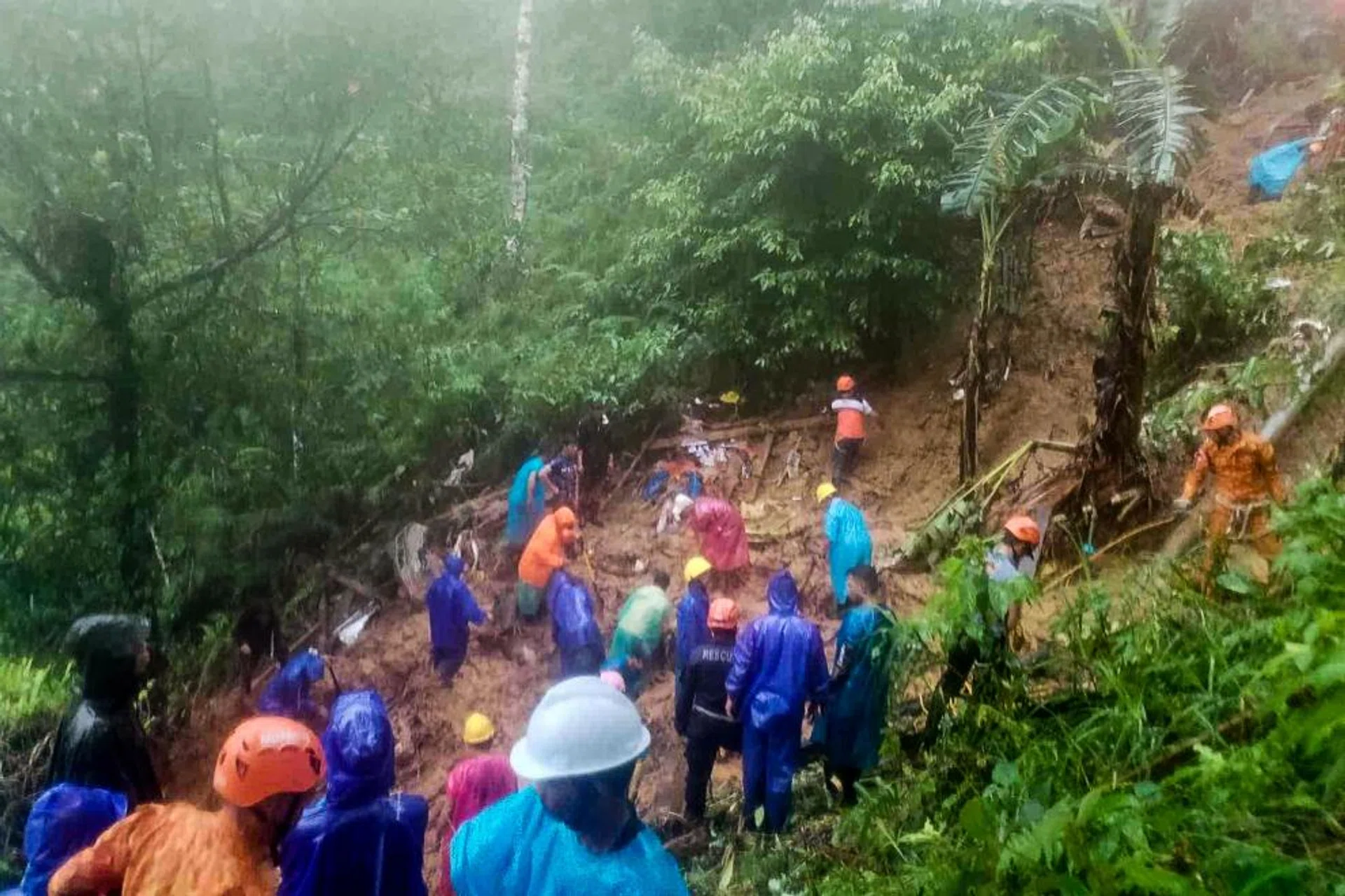 Rescuers on a mission the day after a landslide hit a house in Monkayo.