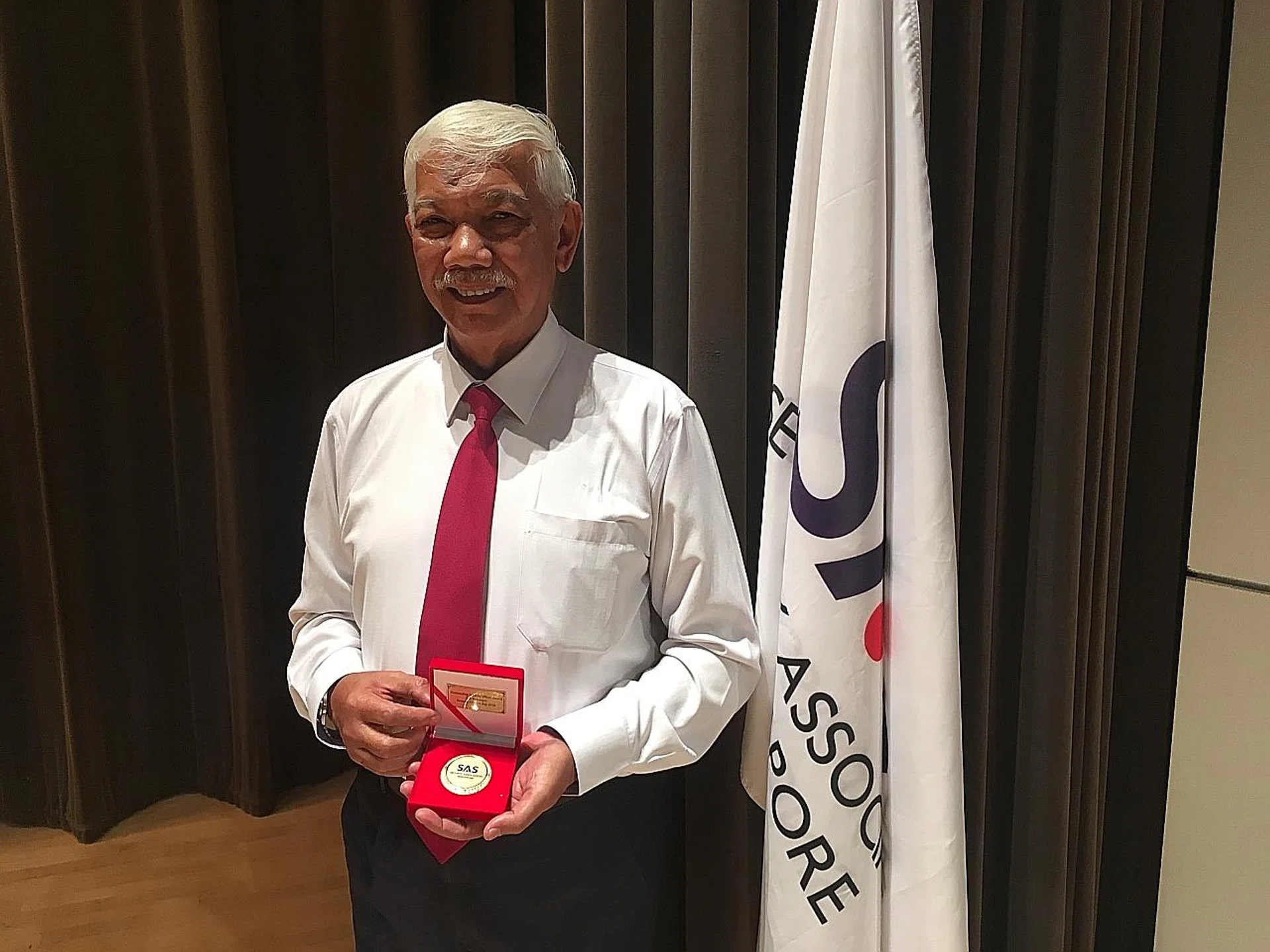 Mr Mohamed Abu Bakar with his Job Redesign Award. 