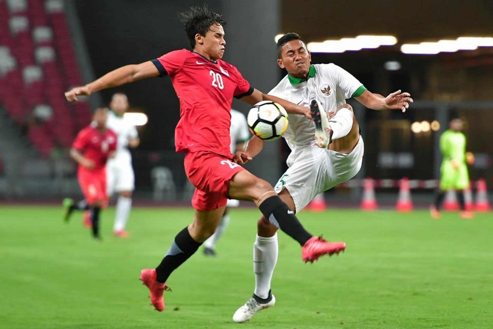 Singapore attacker Ikhsan Fandi (in red) battling with Ricky Fajrin Saputra of Indonesia in their Under-23 friendly match at the National Stadium last night.