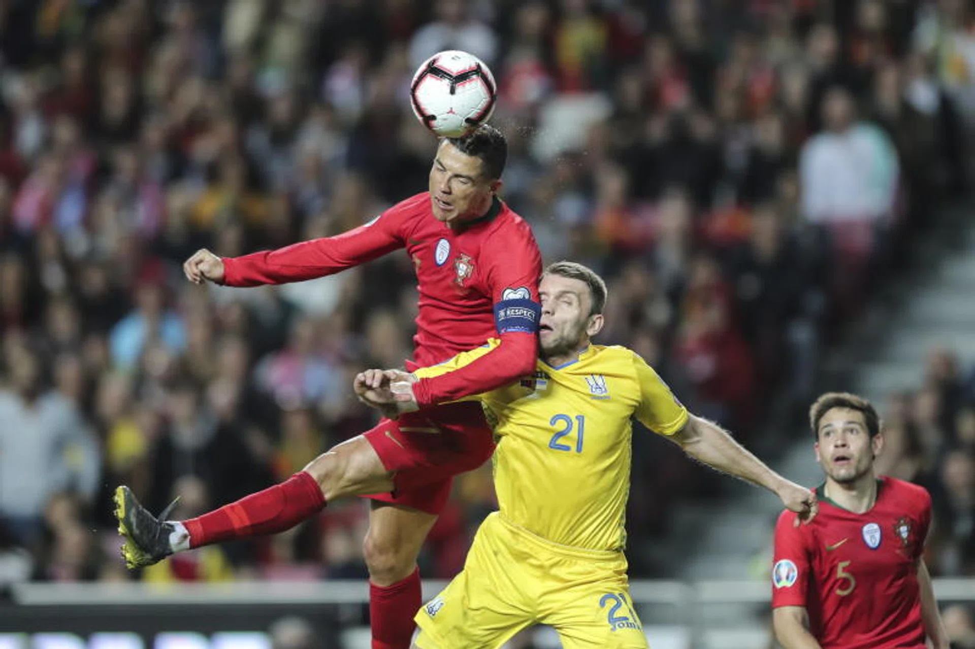 Portugal's Cristiano Ronaldo beats Ukraine's Oleksandr Karavaev to the header.
