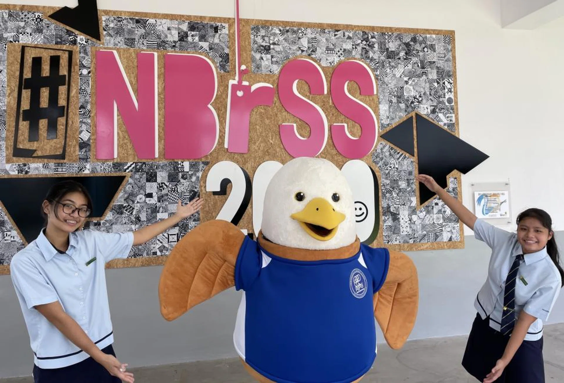 Northbrooks Secondary School's students Vrina Dimayacyac (left) and Erlyn Yussof with the school's mascot