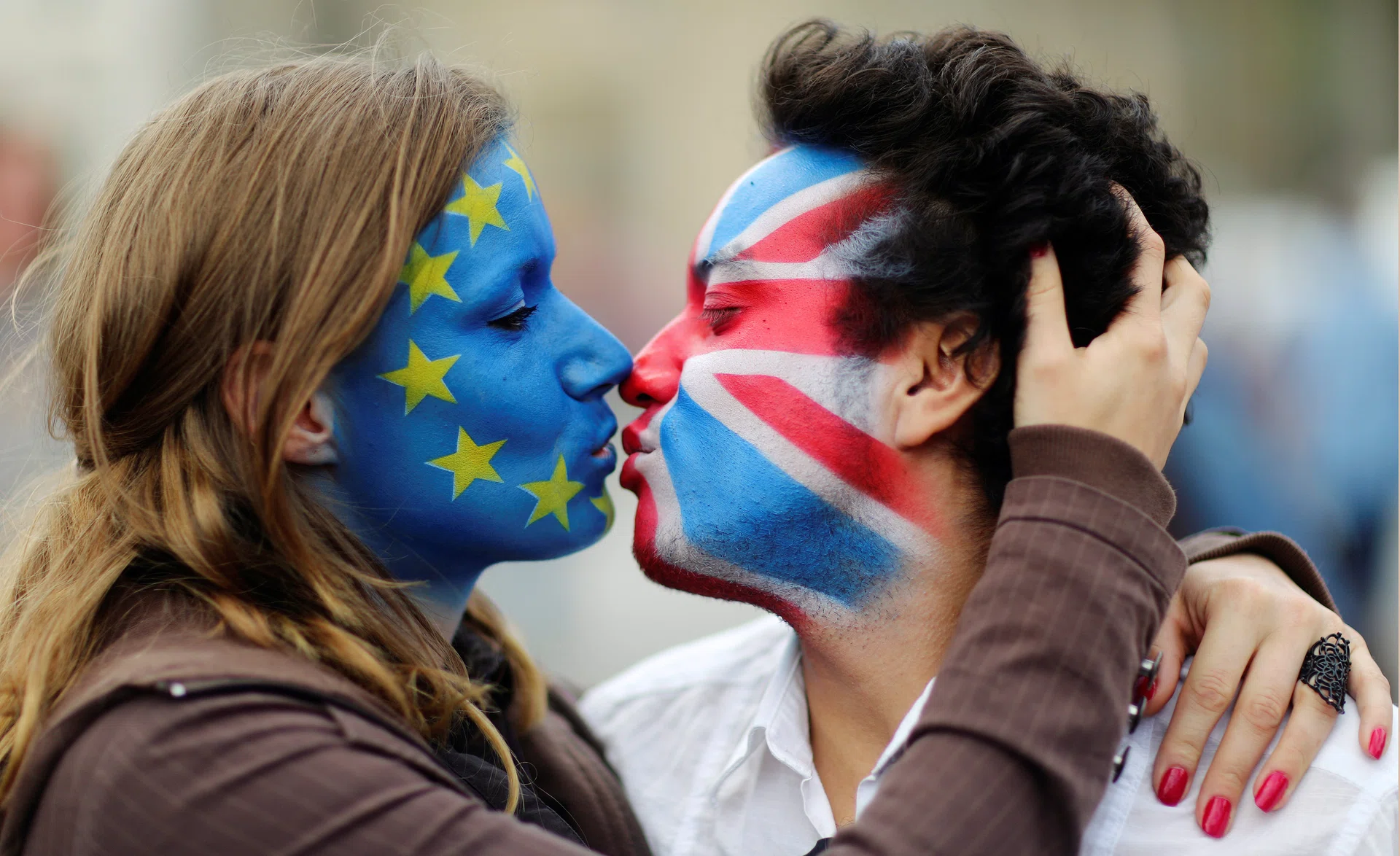 KISS & MAKE UP? Two activists with the EU flag and Union Jack painted on their faces kiss each other, symbolising a preference for the UK to stay in the EU.