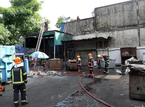 Workers try to put out factory fire