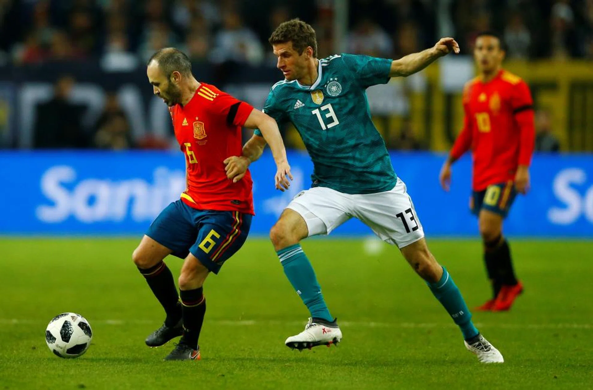 Spain midfielder Andres Iniesta (left) holding Germany's Thomas Mueller at bay.
