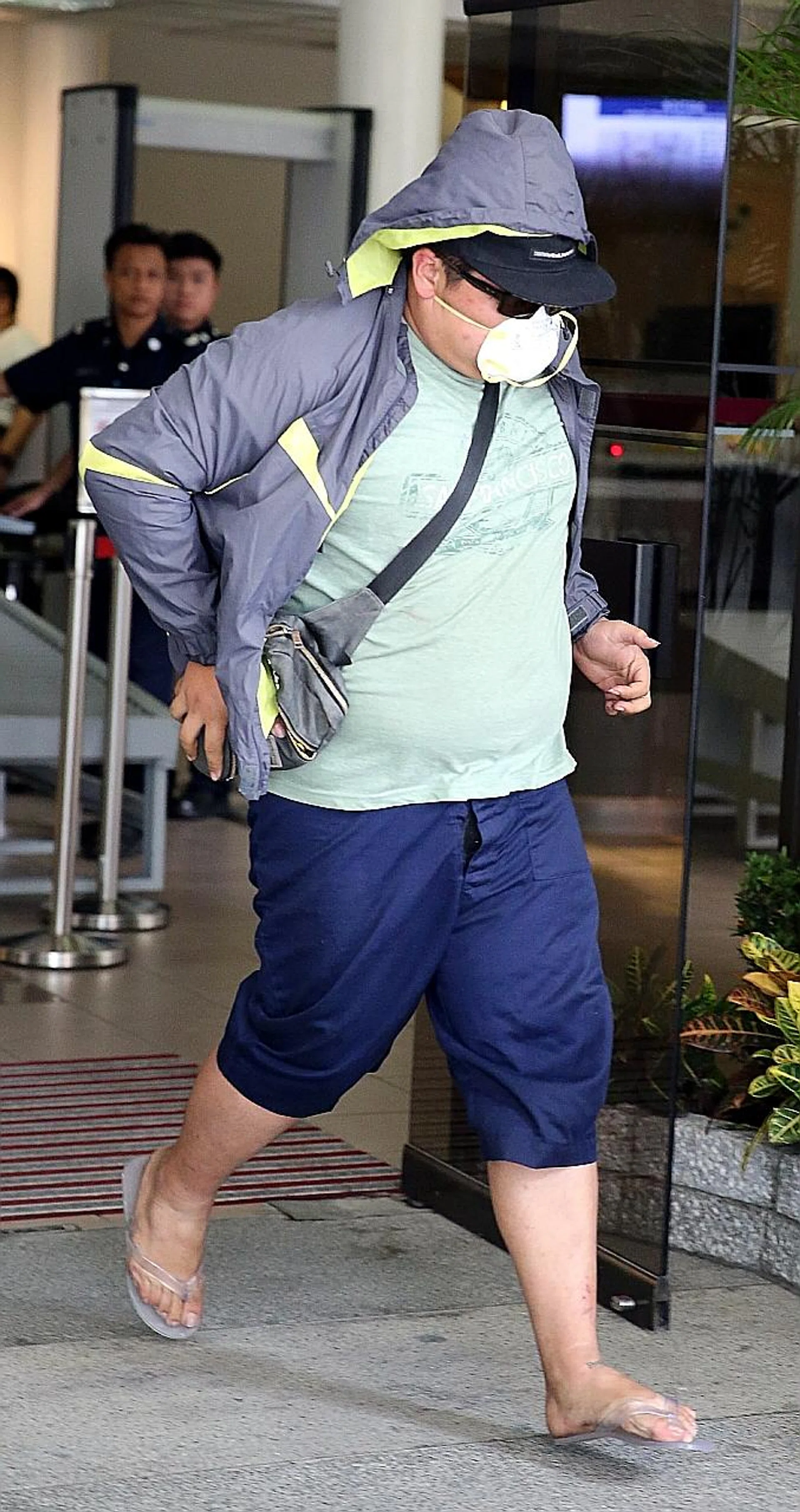 Koh Boon Ping, wearing a mask, was charged in court with two counts of causing death by a rash act in the BKE accident. 