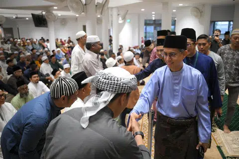 Prof Faishal Ibrahim (right) greets congregants before the Hari Raya Aidiladha prayer at the recently upgraded Masjid Darul Makmur.