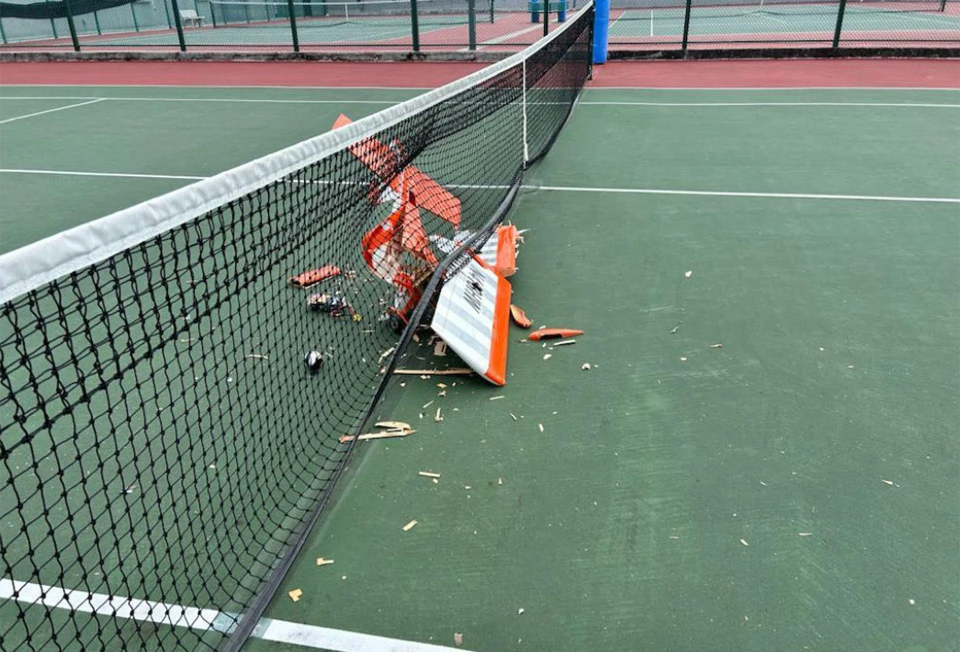 The crashed remote controlled plane caused damage to the tennis court.