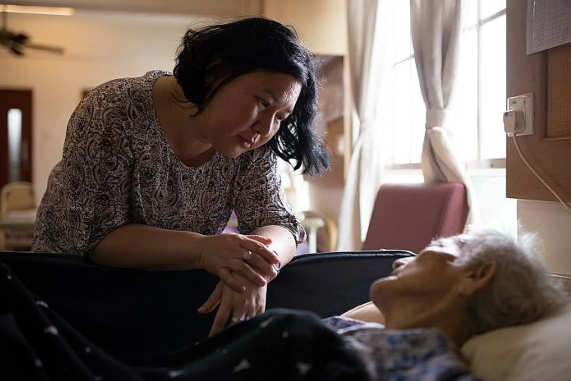 SUPPORT: Medical social worker Lola Ng with one of her patients.