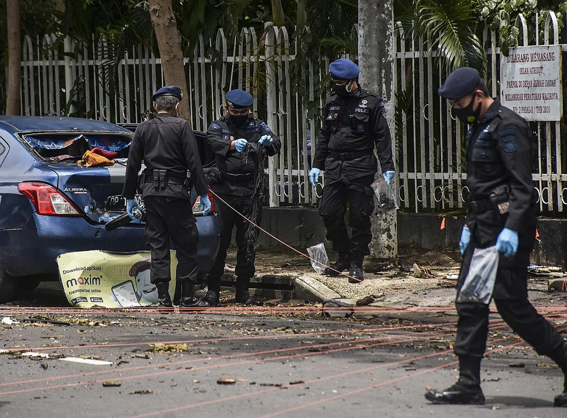 Police officers investigating the blast site outside the Sacred Heart of Jesus Cathedral. PHOTO: EPA