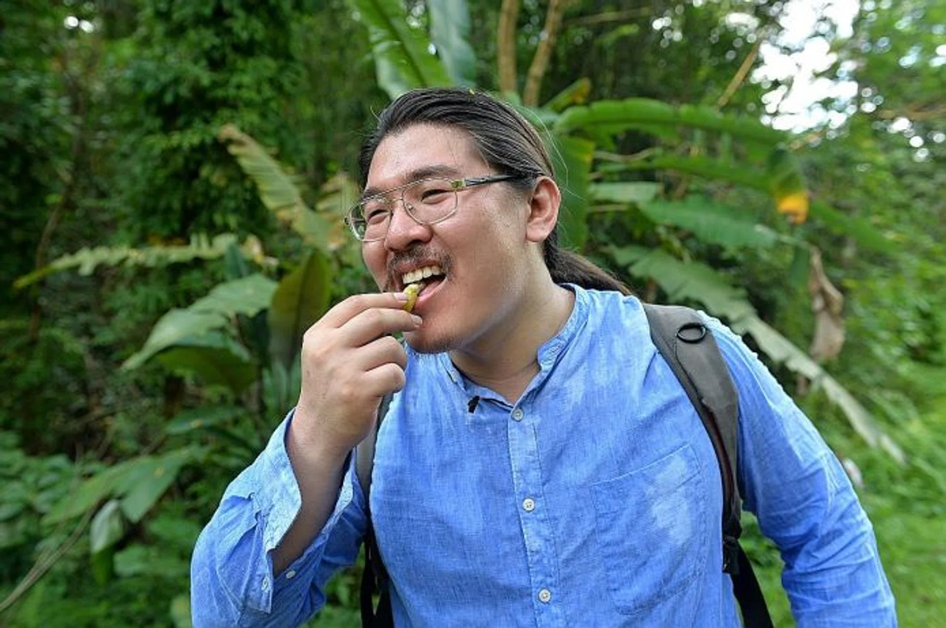 TINY SNACK: (Above) Mr Esmonde Luo biting into a ripe banana he found along the trail.