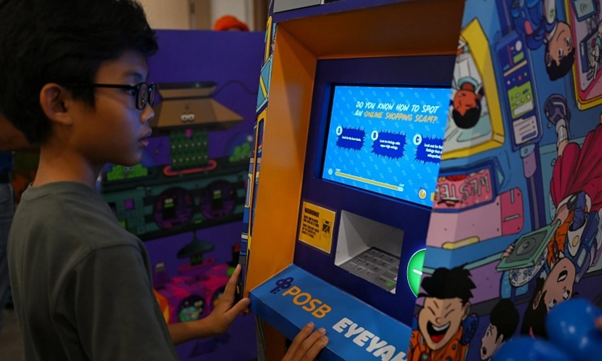 Chiong Tze Yu, 13, answering a question about online shopping scams on a "children's ATM" featuring an interactive game. 