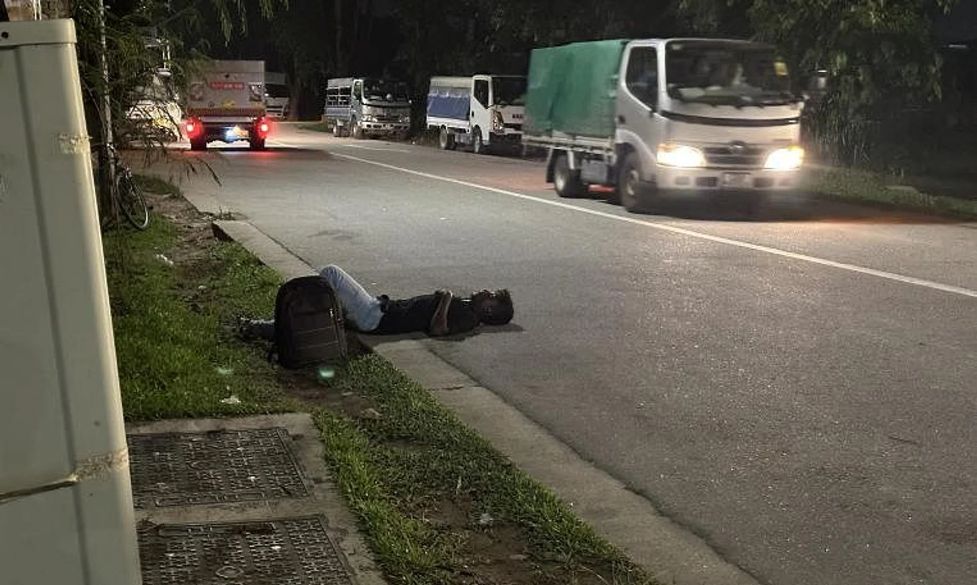 A migrant worker sleeping off the effects of alcohol on the road, as vehicles gave him a wide berth.