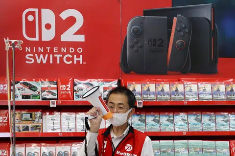 A staff member at an electronics store in Tokyo holds a megaphone on June 5, the day Nintendo starts selling the Nintendo Switch 2 game console globally.