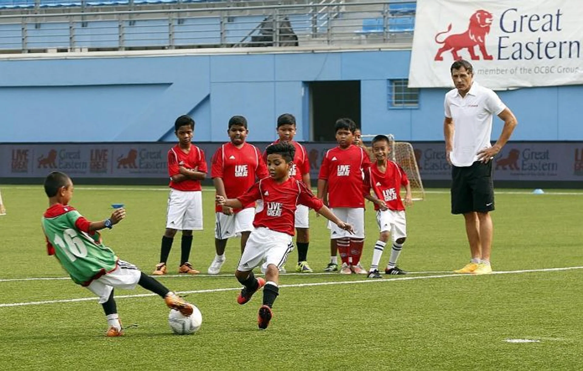 RIGHT FIT: Aleksandar Duric (far right) conducting a kids' football clinic last year as part of Great Eastern's SG50 Wishes campaign.