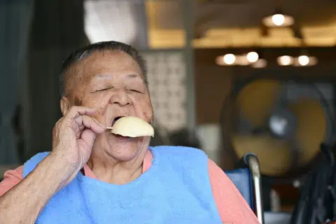 Madam Chua Lian Tee, 85, tucking into a stick of durian ice cream brought by her daughter.