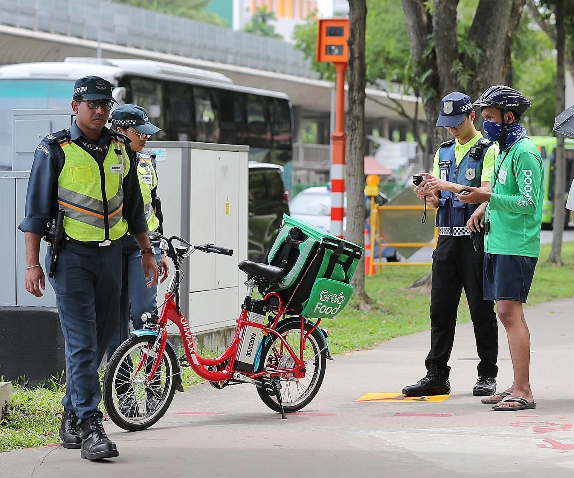 A power-assisted bicycle rider who was caught by LTA enforcement officers and auxiliary police while riding his PAB on the footpath in Ang Mo Kio yesterday. 