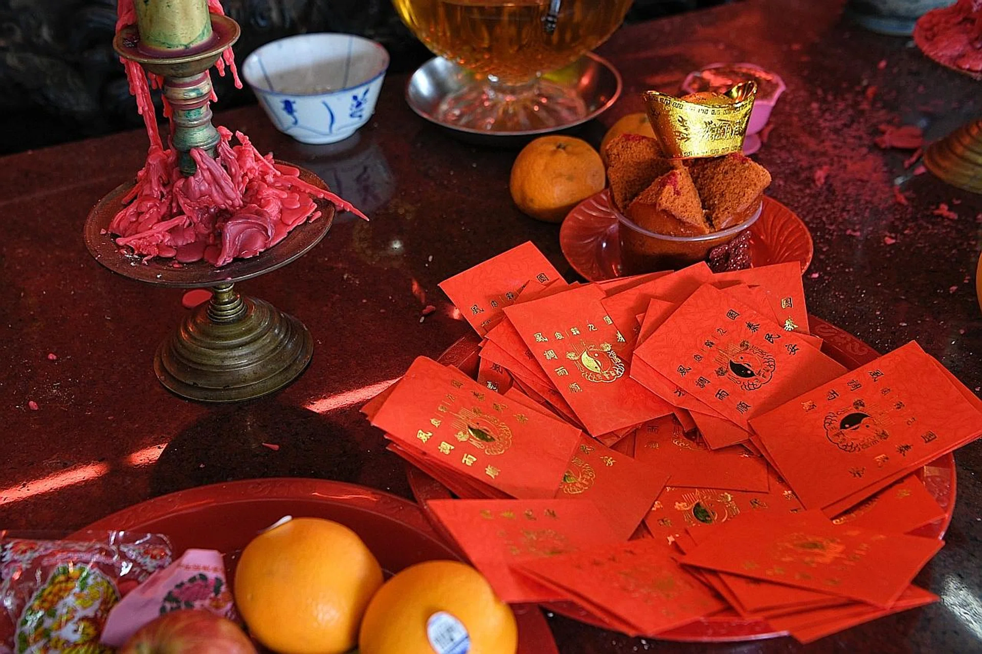 A woman helped herself to about 500 "good luck" red packets at a temple in Choa Chu Kang on Feb 5 (above). 