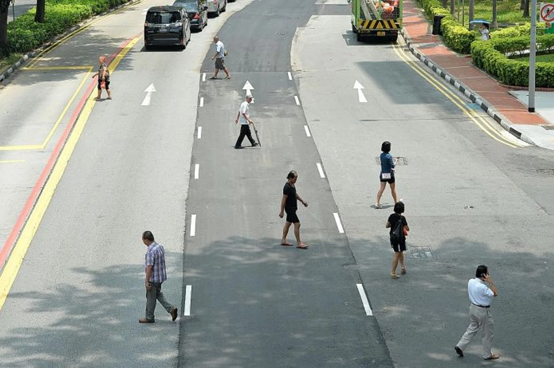 STUBBORN: Madam Chen could not dissuade her friend (above) from jaywalking with a toddler in a pram.