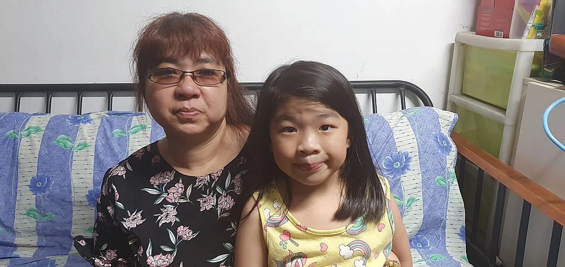 Madam Tan Hwee Li, now her family's sole breadwinner, with her daughter Chong Yee Lin. 
