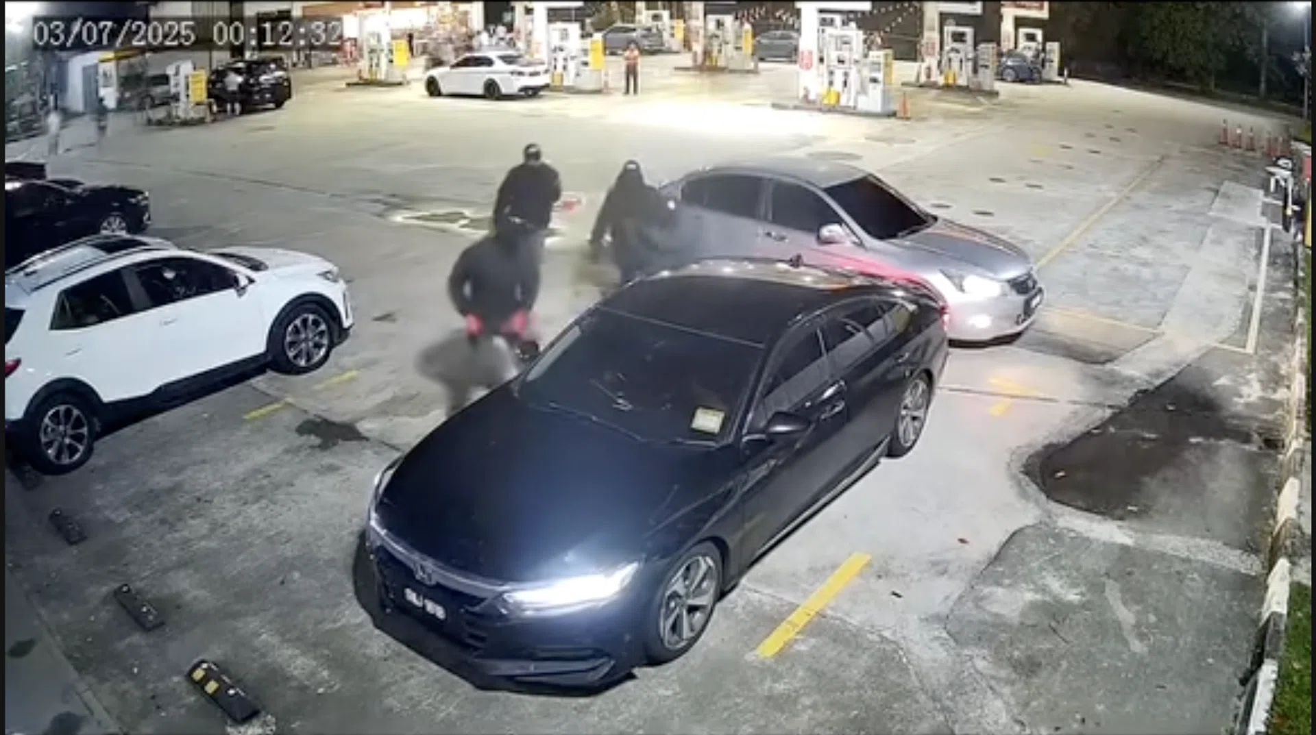 Four masked men armed with machetes attacking the parked car. 