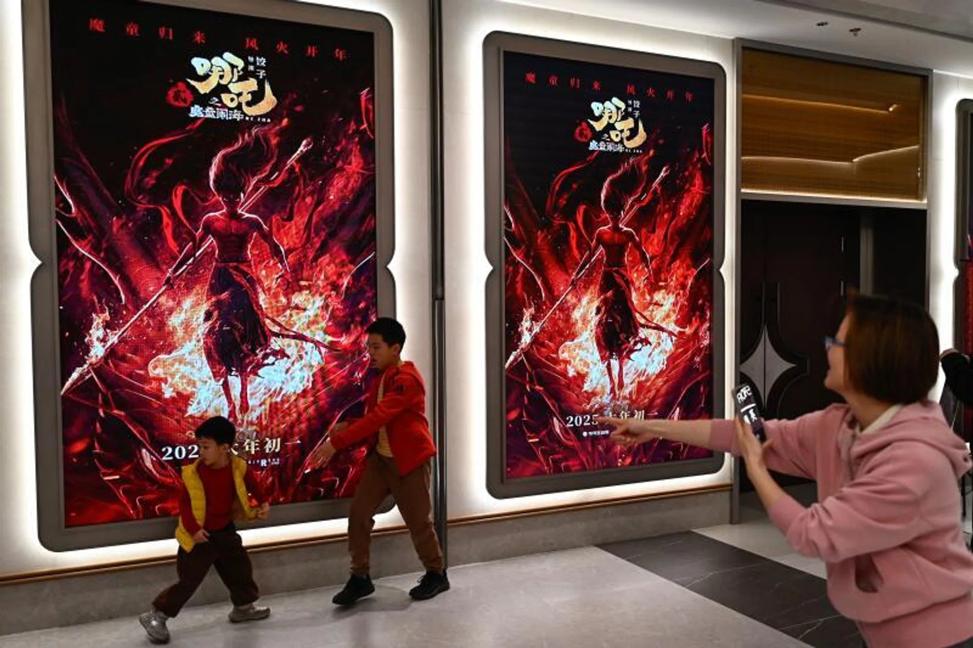 Children pose for a picture as they visit a movie theatre to watch the animated film Ne Zha 2 in Beijing on Feb 16.