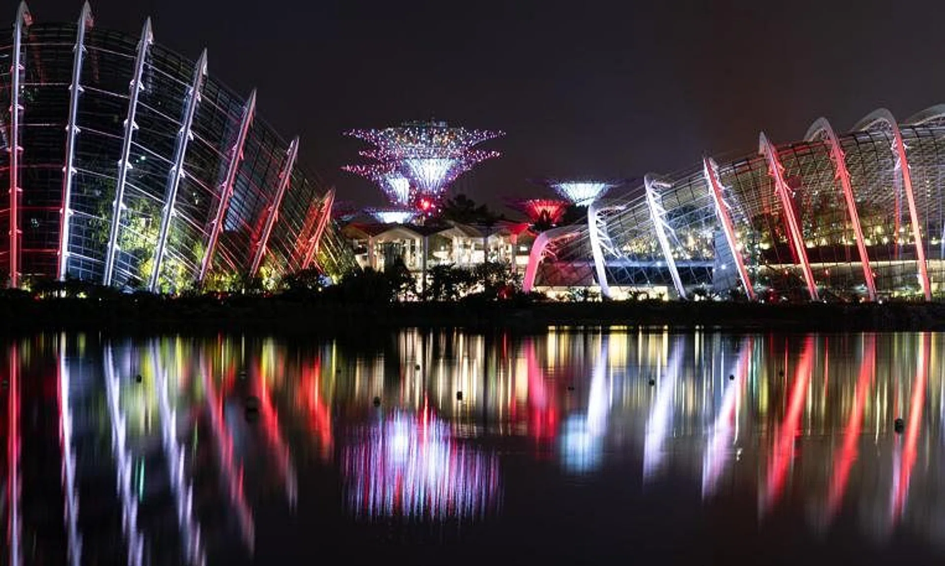 The cloud forest, Supertrees and flower dome being illuminated in red and white at Gardens by the Bay, on June 28, 2024.