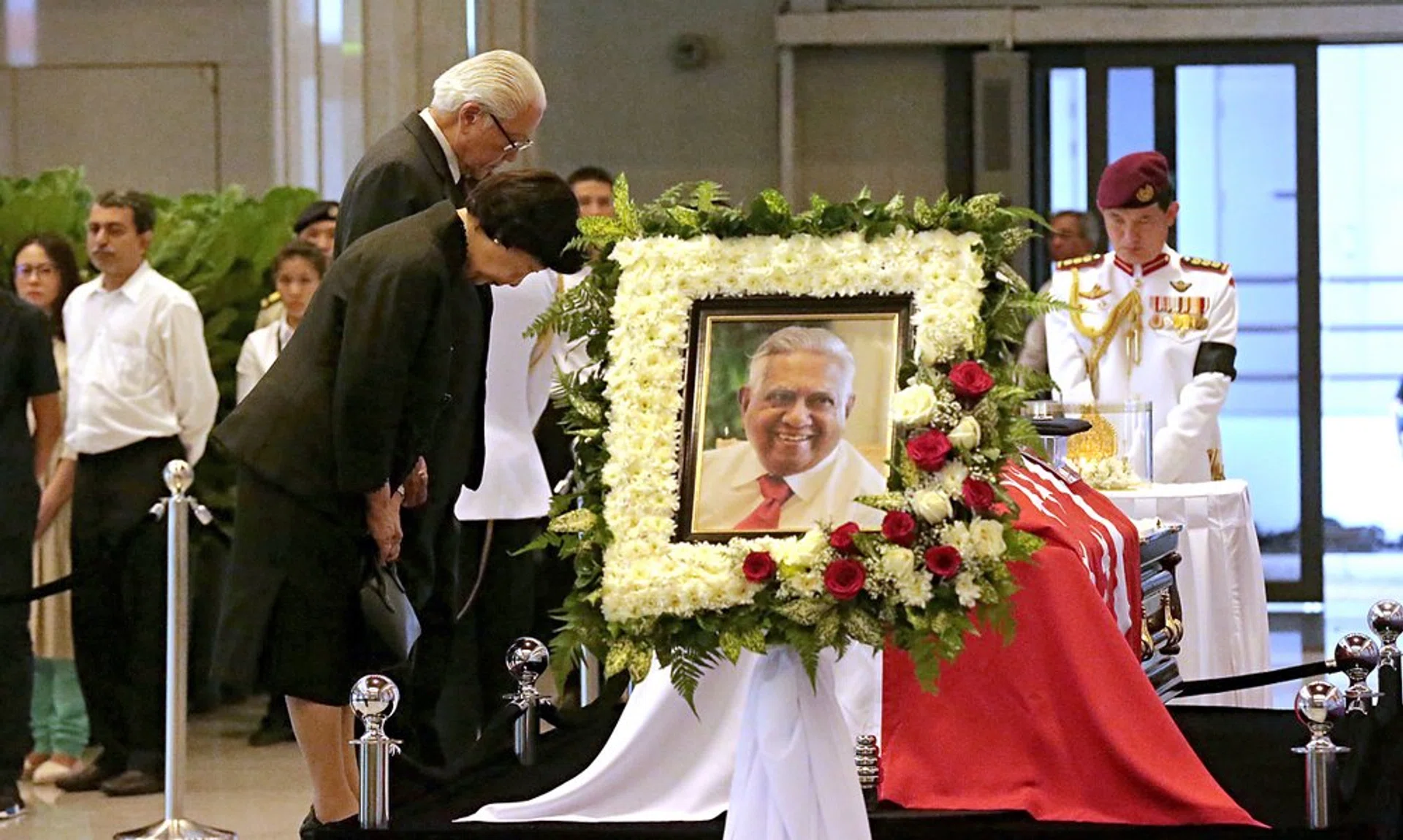 Preisdent Tony Tan Keng Yam and his wife Madam Mary Chee bow in front of Mr S R Nathan's casket at Parliament House.