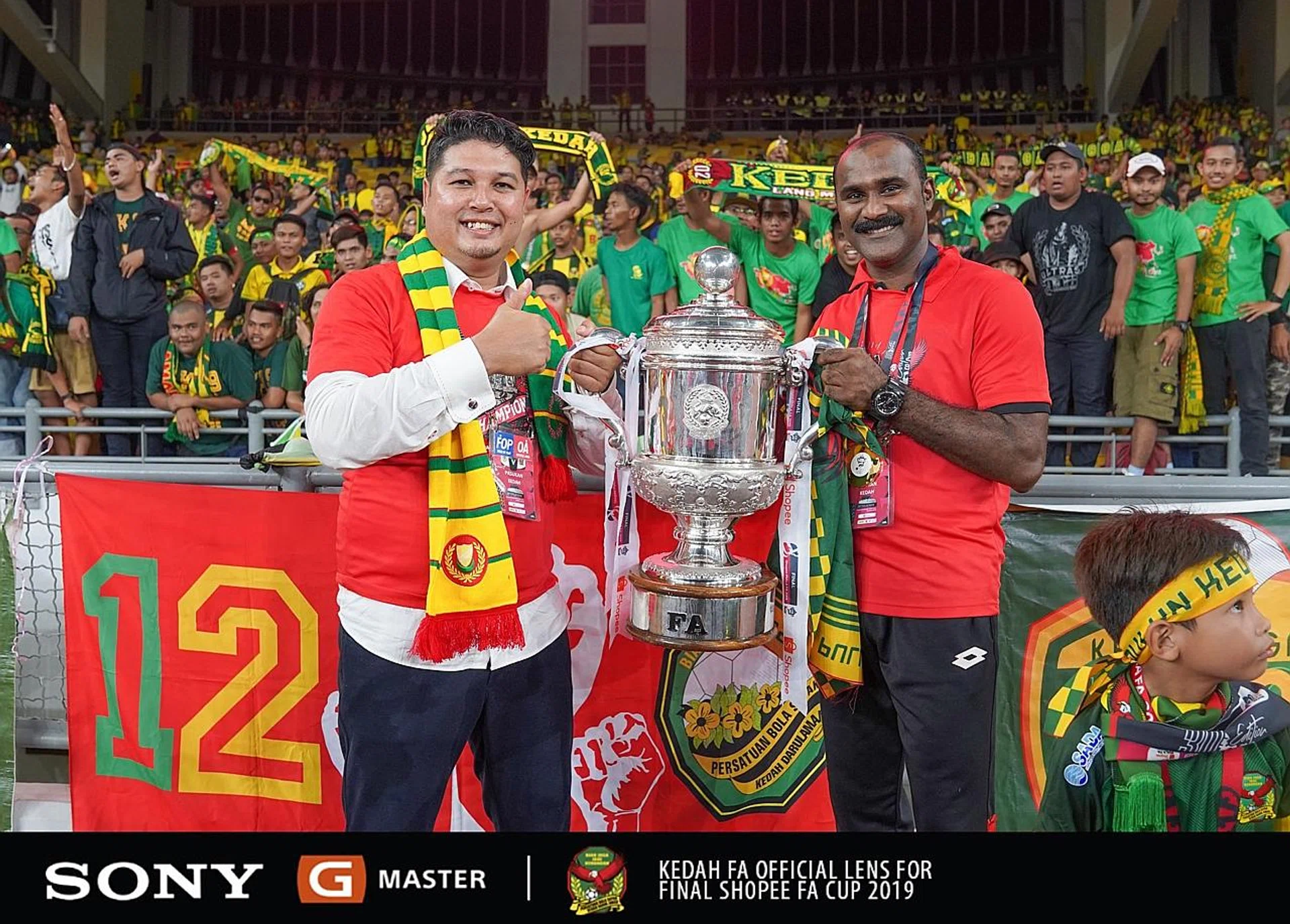 Kedah coach Aidil Sharin (left) and assistant coach Victor Andrag showing the FA Cup to their jubilant fans at the Bukit Jalil National Stadium on Saturday.
