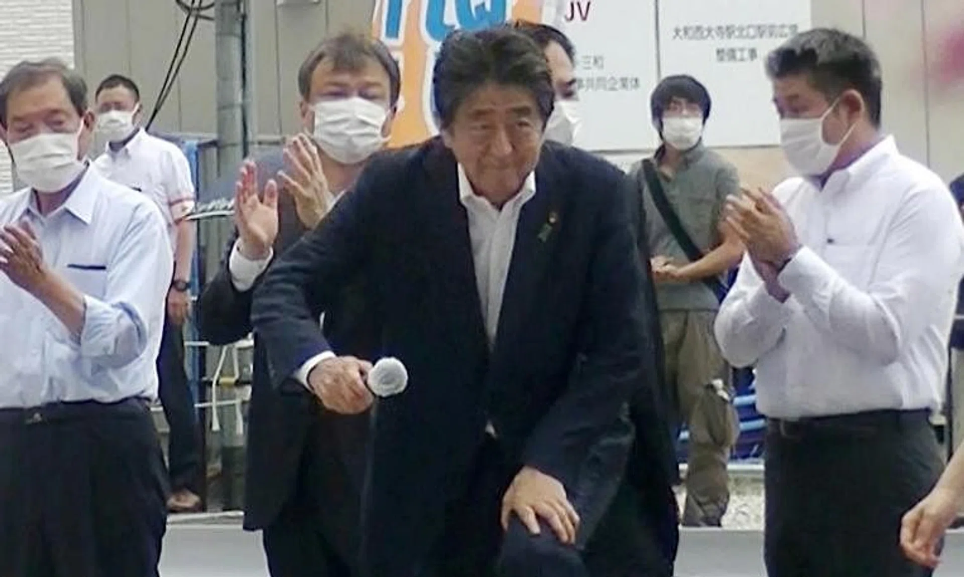 Former Japanese PM Shinzo Abe (centre) attending an election campaign in Nara, while suspect Tetsuya Yamagami (in grey) stands in the background shortly before Mr Abe was shot.