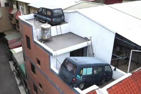 Frustrated with fines, man in Taiwan parks vans on his rooftop