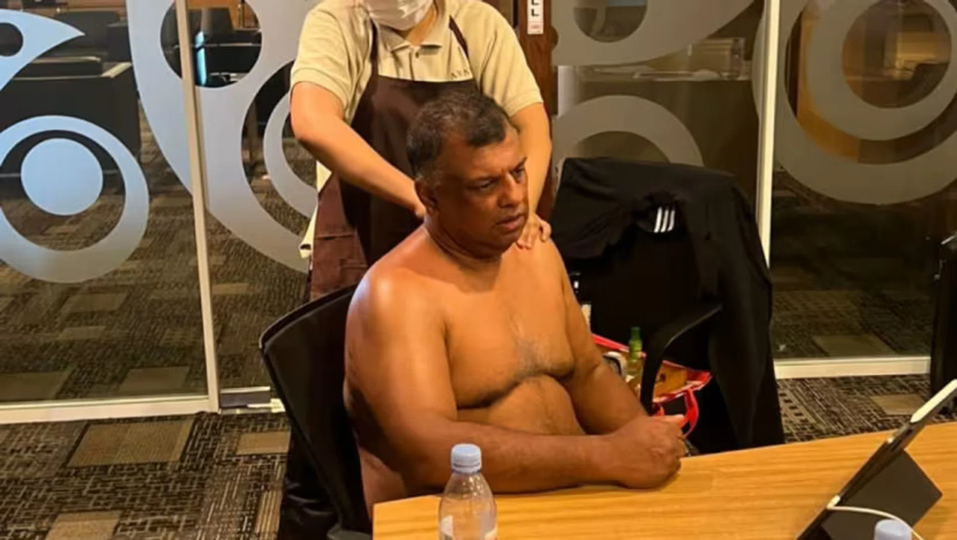 A shirtless Tony Fernandes, AirAsia CEO, getting a massage during a conference call. 
