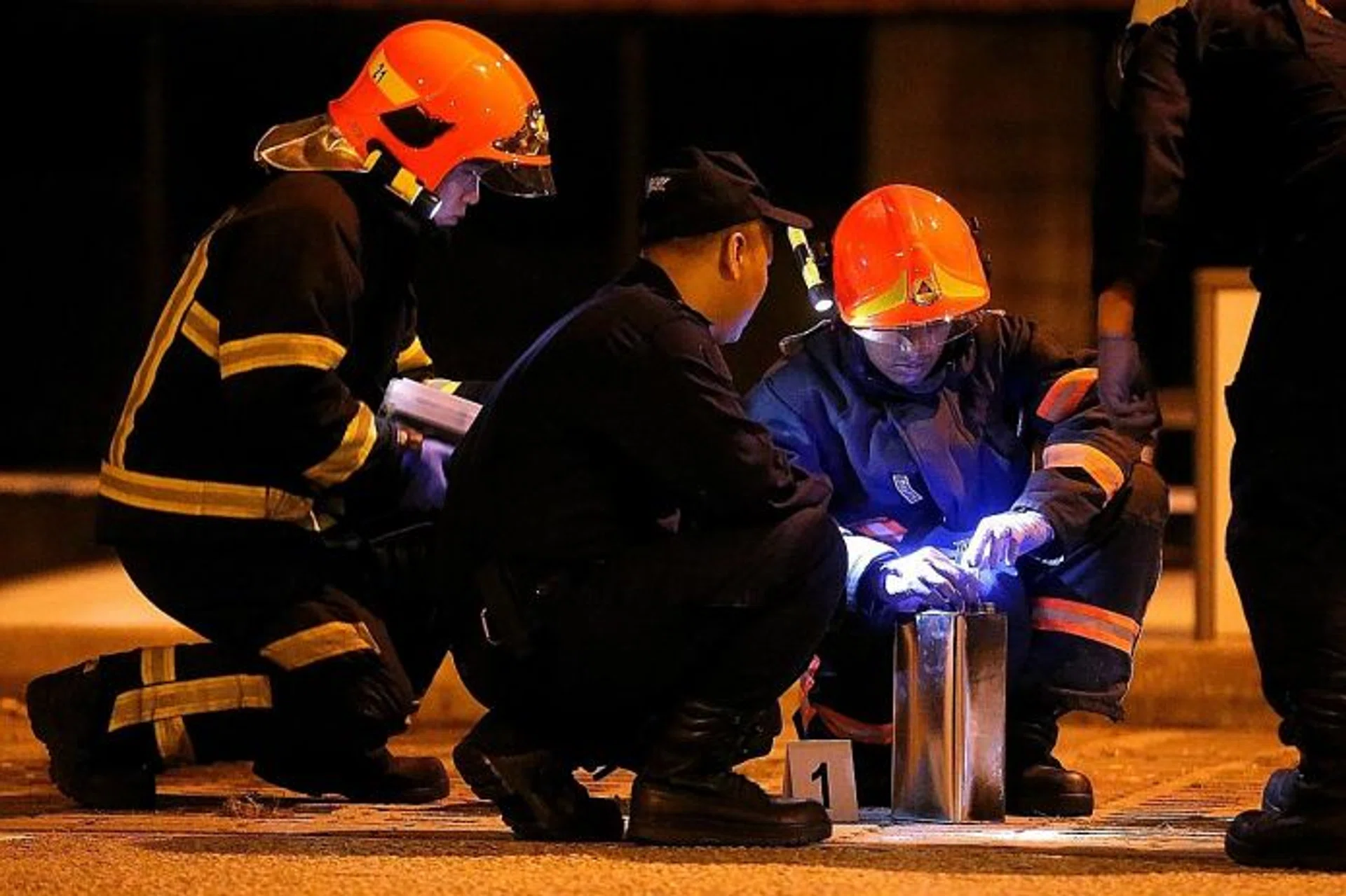 HELP: SCDF officers with the can containing flammable liquid that the man used to set himself on fire.