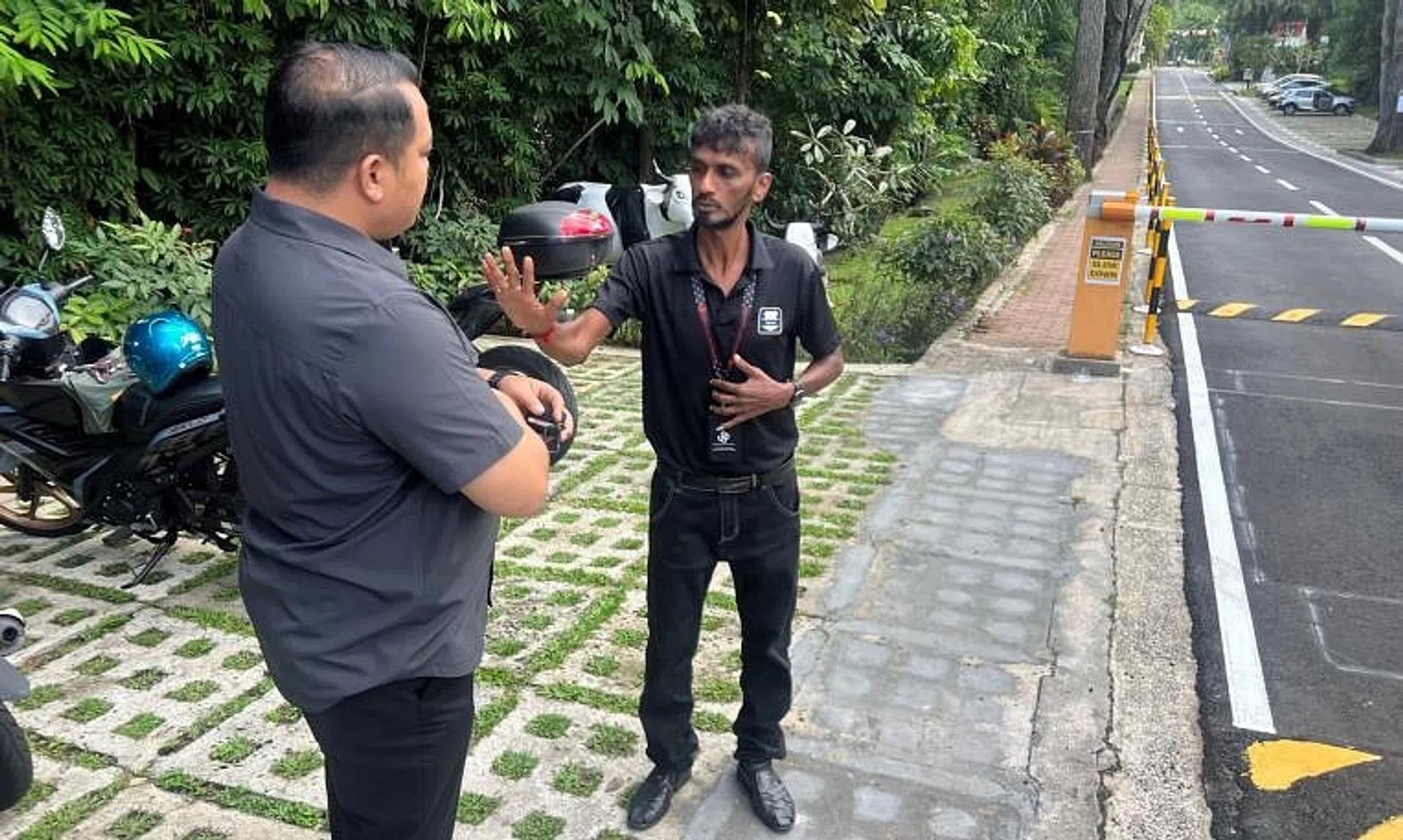 An executive council member of the Union of Security Employees (left) visiting the security officer, identified as Brother Chandra.