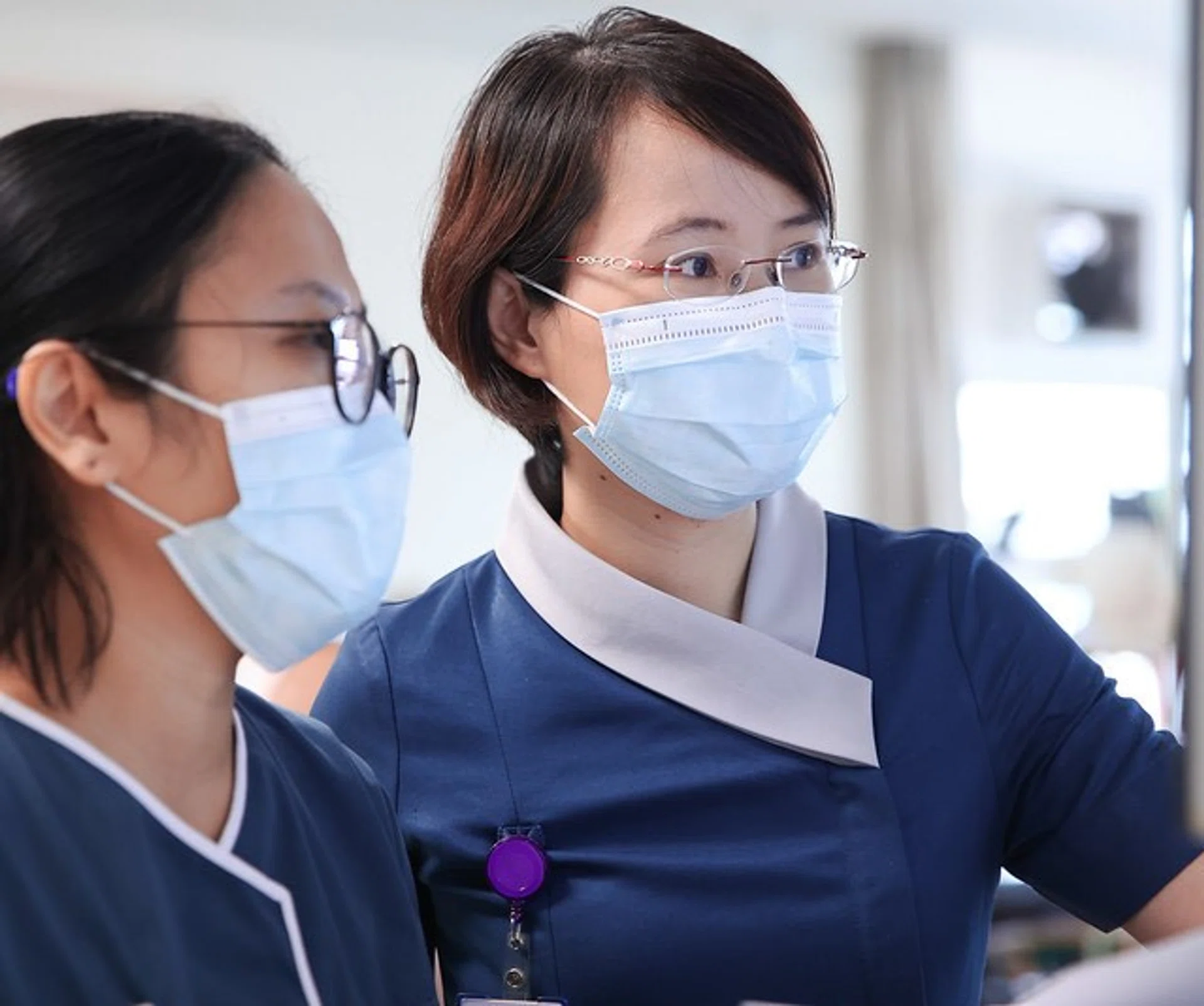 Nurse clinician Chen Lin (right) discussing a case with assistant nurse clinician Glenda Maris. 