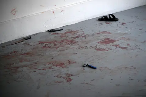 A knife, a watch, a mobile phone, a set of car keys and a slipper lay on the bloodied floor.