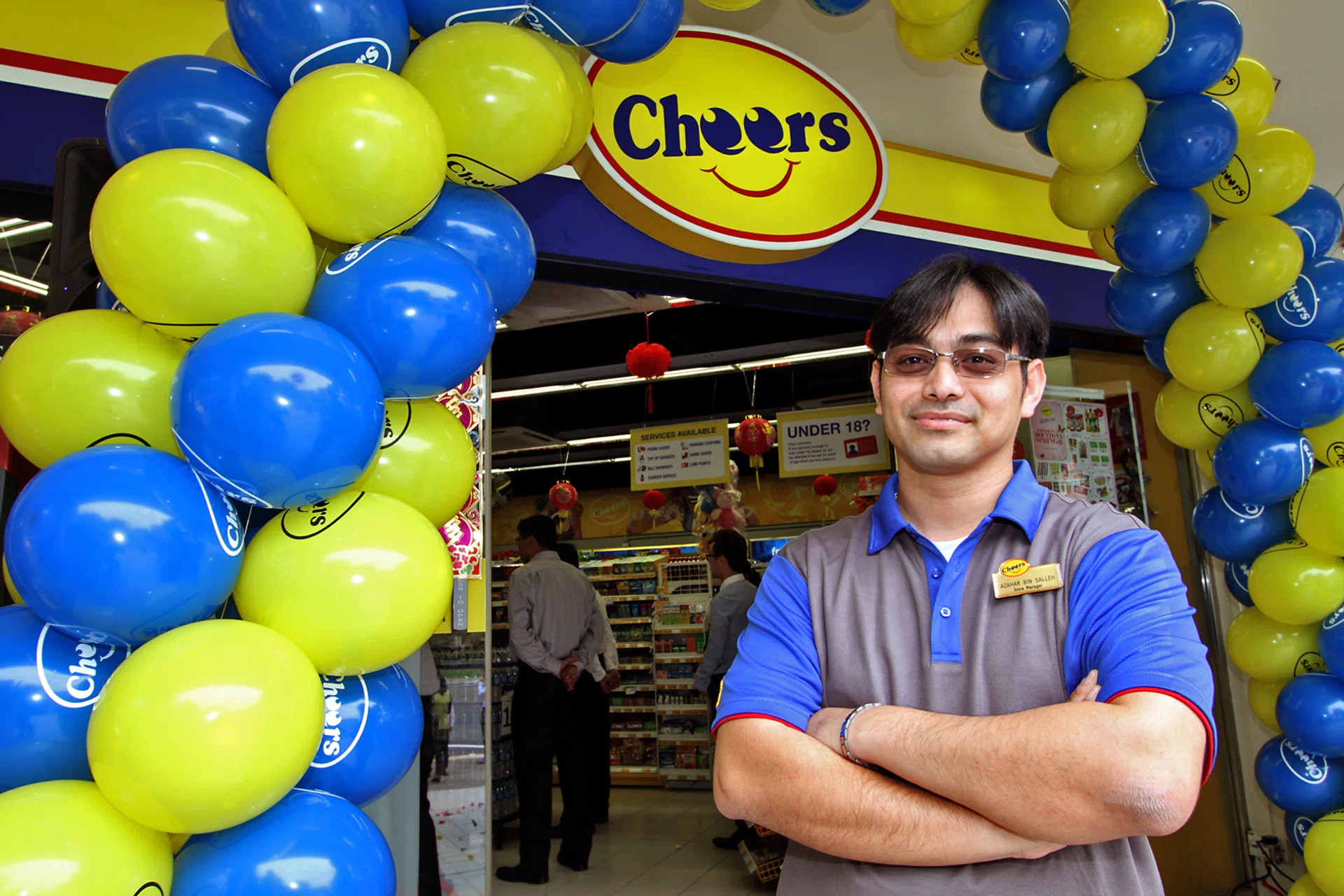 THEN: Azahar Salleh in an old photograph taken outside his Cheers store in Choa Chu Kang. 