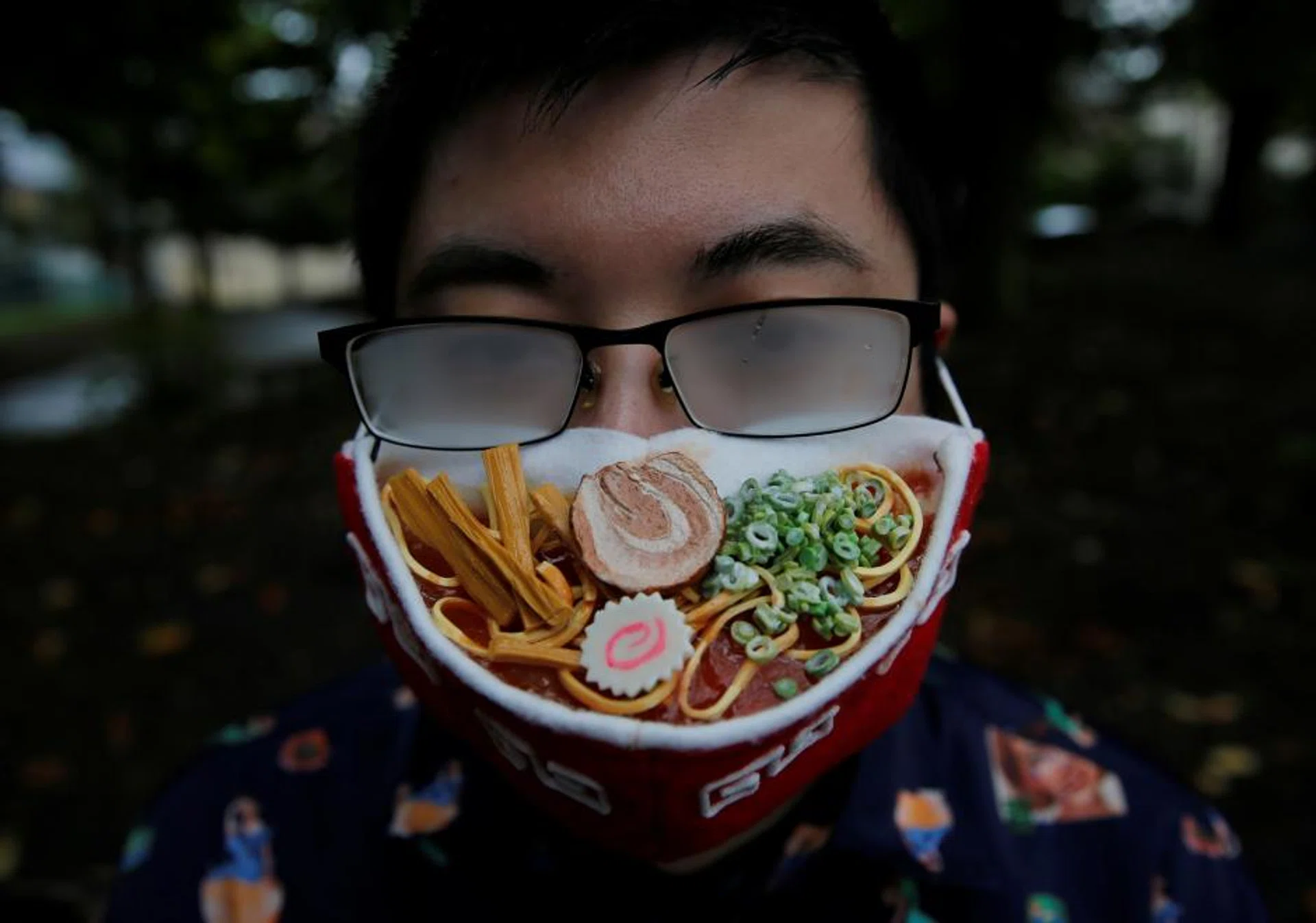 Japanese designer Takahiro Shibata's glasses fog up as he wears a protective mask that looks like a steaming bowl of ramen noodle soup while posing for a photo at a park, following the coronavirus disease (COVID-19) outbreak in Yokohama, Japan September 23, 2020.