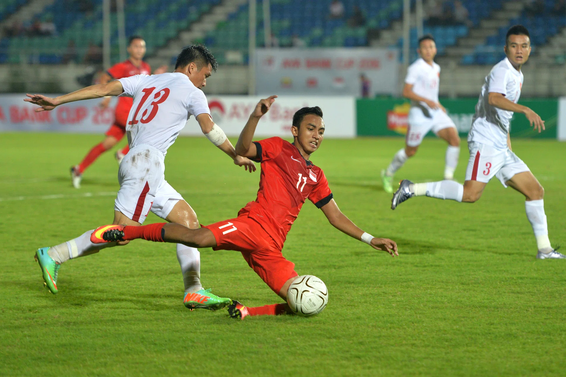 DOWNED: Faris Ramli (in red) struggling against the Vietnam players.