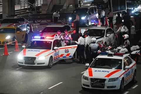 Traffic Police officers escorting a motorist suspected of drink driving to a patrol car during the Sept 20 operation in Upper Cross Street.