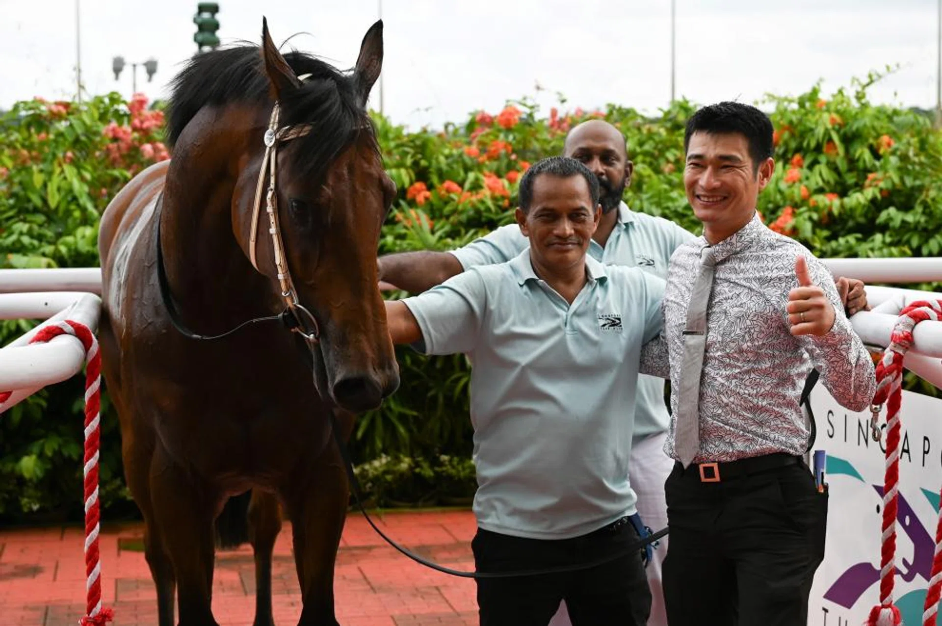 A proud trainer Richard Lim giving the thumbs-up sign when posing with Super Salute, who gave him his first feature success by capturing the Group 3 New Year Cup (1,200m) on Jan 6. In splendid shape, Super Salute can follow up in the Group 3 Fortune Bowl (1,400m) at Kranji on Feb 11.