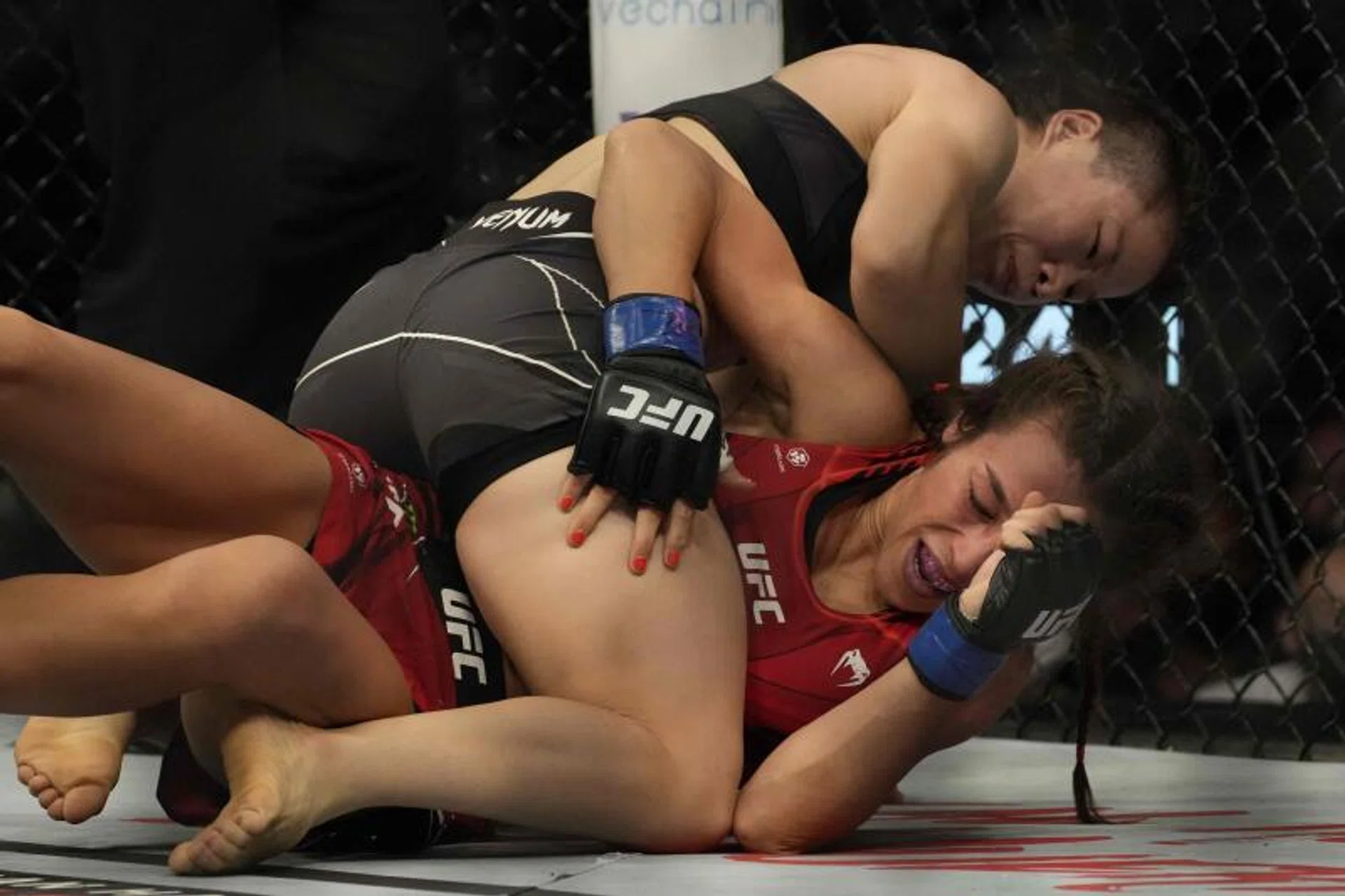 Zhang Weili of China (top) competes with Joanna Jedrzejczyk of Poland in the women’s strawweight bout at the UFC 275 event in Singapore on June 12, 2022.