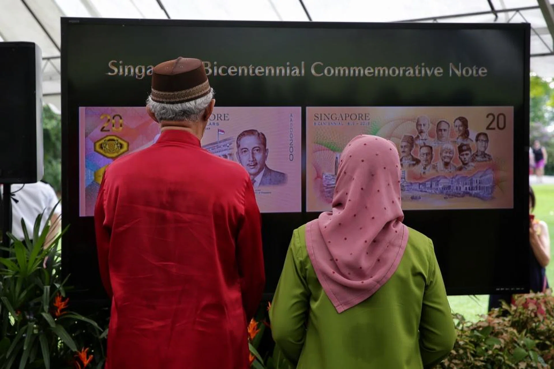 President Halimah Yacob and her Husband Mr Mohamed Abdullah Alhabshee watching a video before launching the Singapore Bicentennial Commemorative Note.