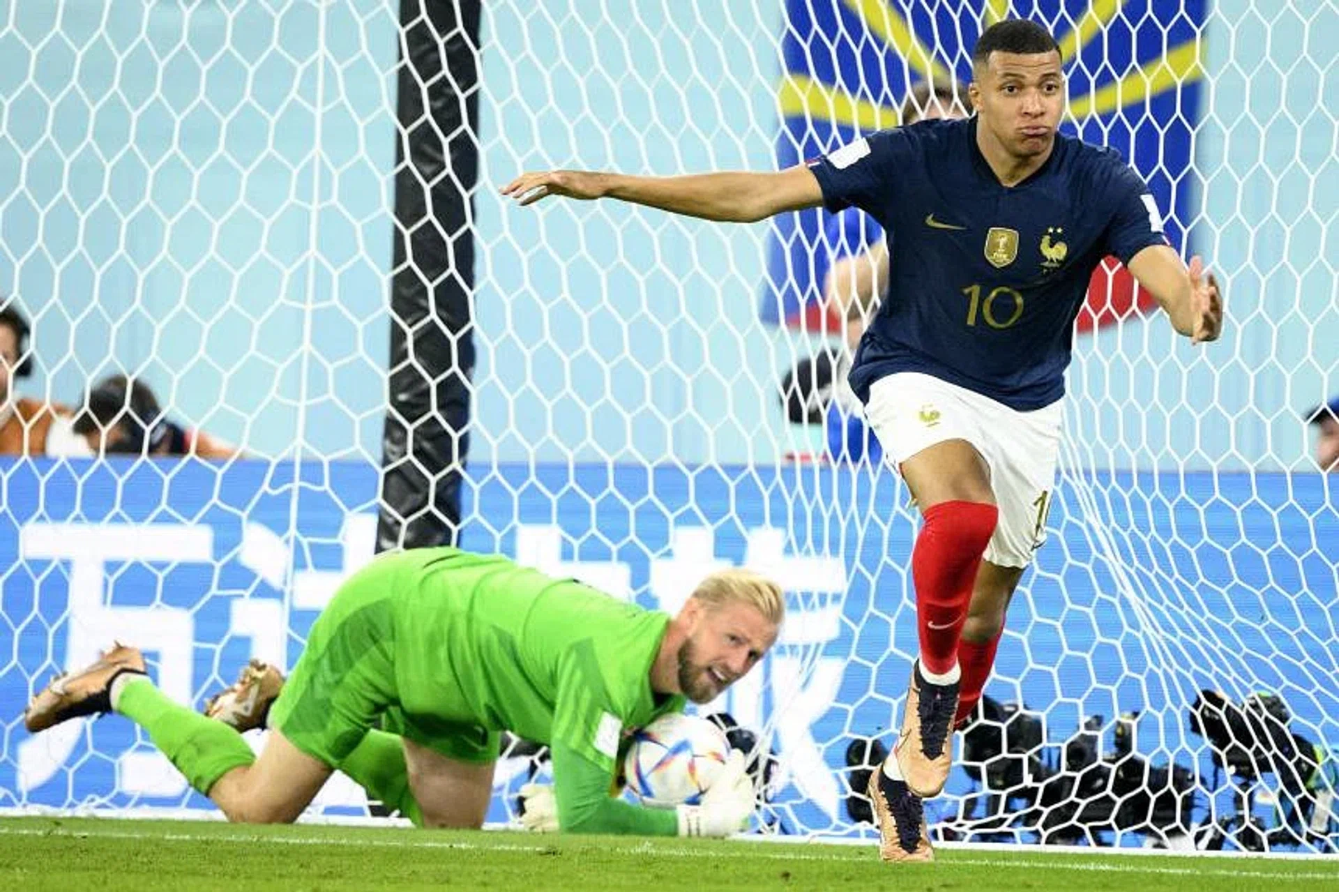 Kylian Mbappe celebrates after scoring his second goal for France against Denmark's goalkeeper Kasper Schmeichel. 
