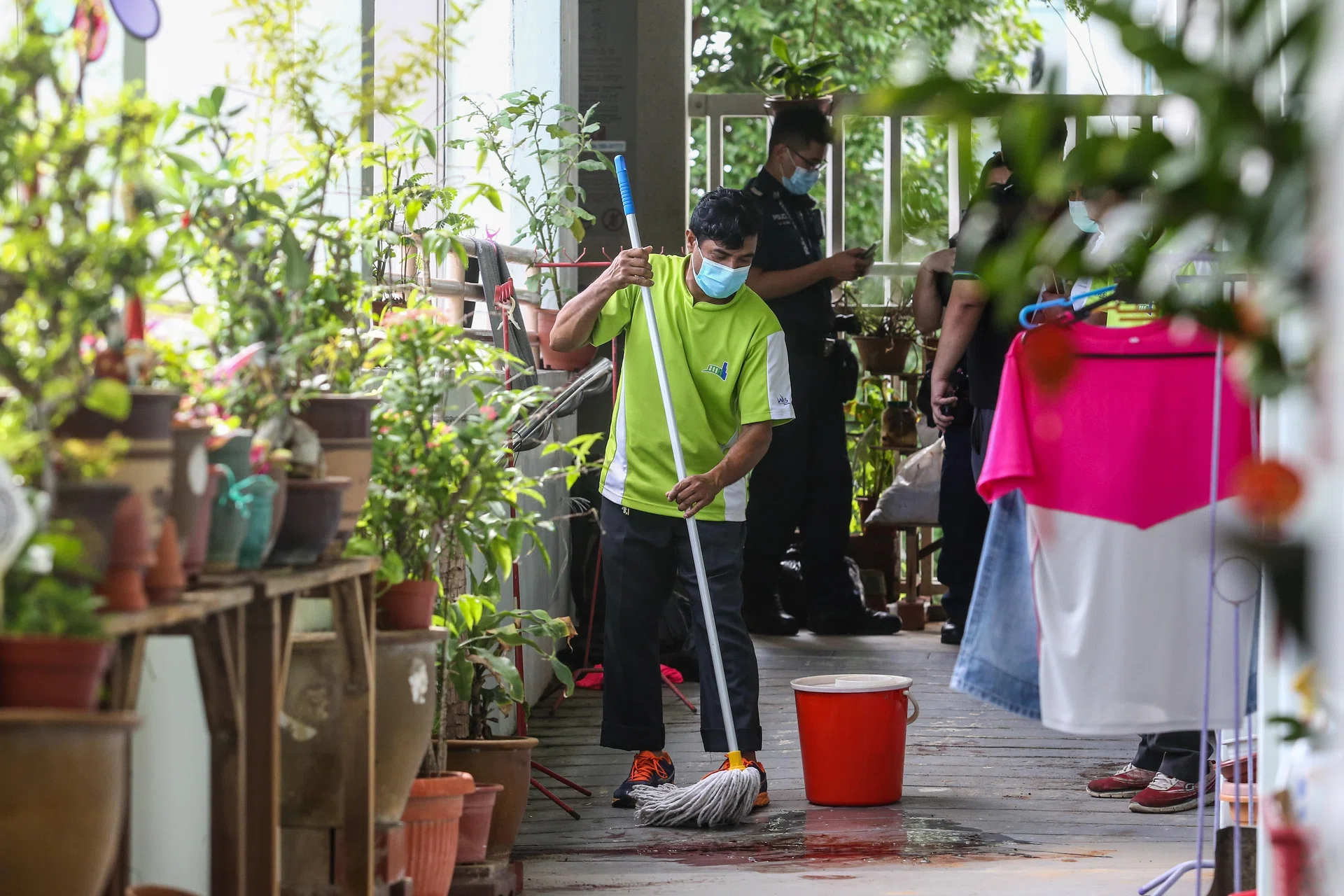A worker cleaning up the bloodstains along the corridor of Block 562 Ang Mo Kio Avenue 3 on July 15, 2021.