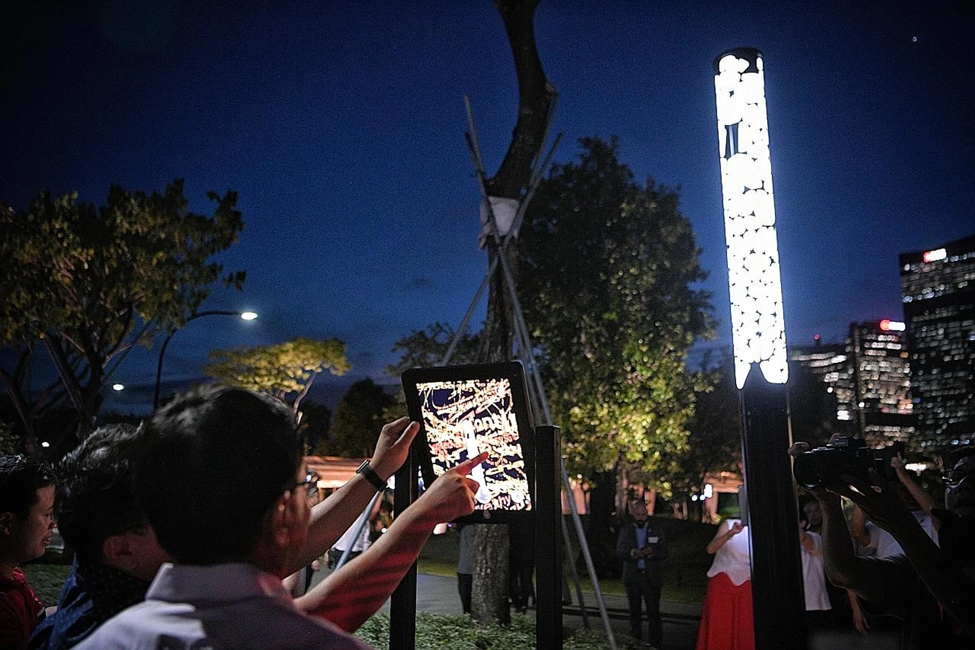 Gardens by the Bay senior director of gardens operations Andy Kwek assisting Deputy Prime Minister Heng Swee Keat as he writes his message on the Message Pillar app at the launch of the #futuretogether exhibition. 