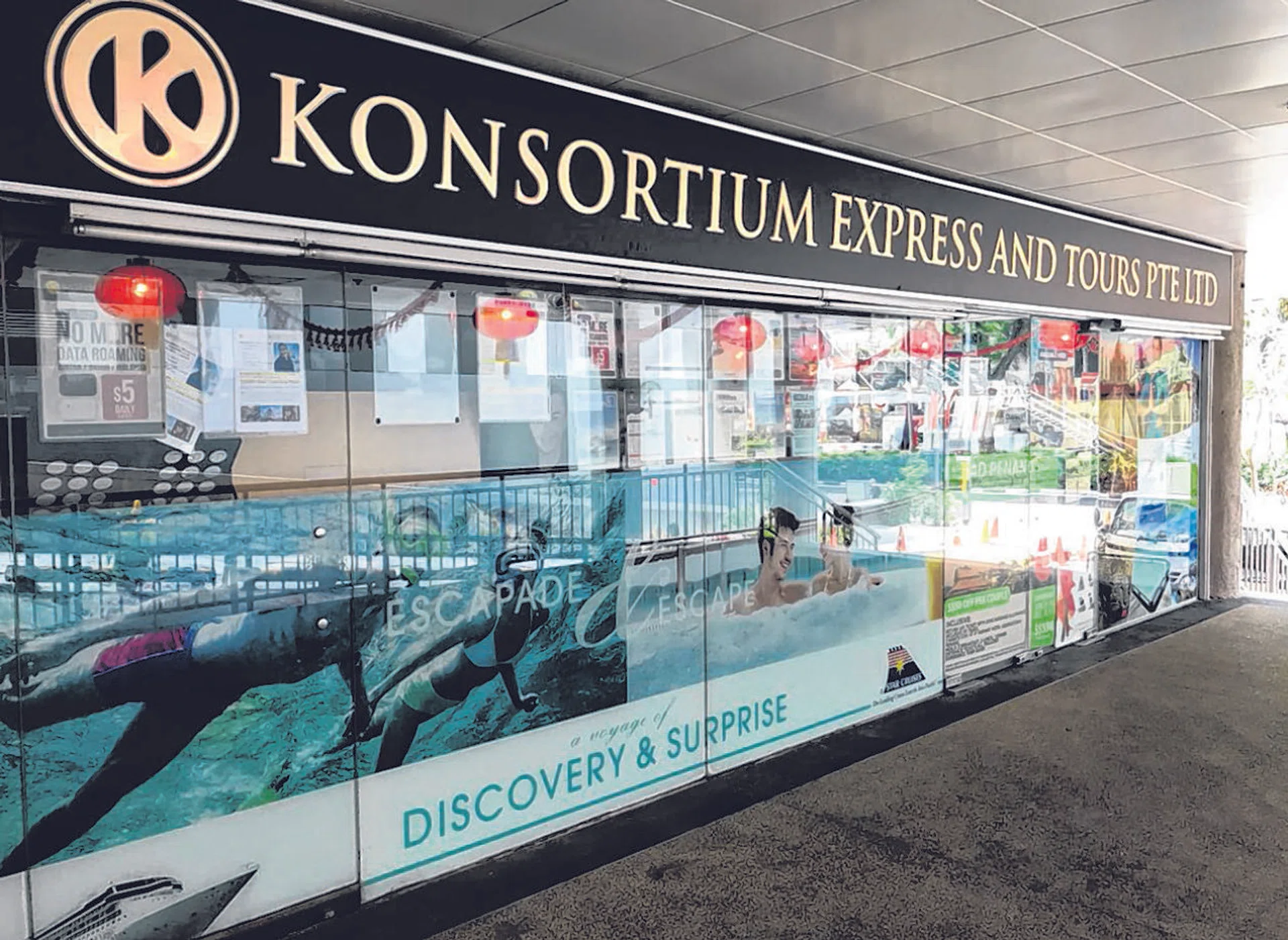 Konsortium Express And Tours at Golden Mile Tower with a notice on the front door saying the company has closed due to a "financial crisis". 